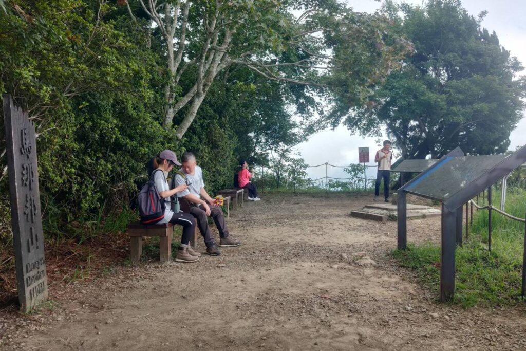 山友在馬拉邦山山頂平台休息，欣賞風景，展現這條老少咸宜的苗栗登山步道的魅力。